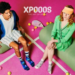 Model draagt kleurrijke XPOOOS sokken op een tennisbaan